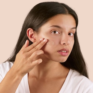 Mujer aplicando crema facial  hidratante para nutrir y proteger la piel sin sensación pesada.